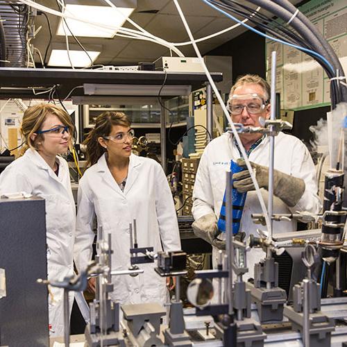 Students talking with professor in lab